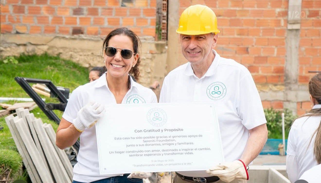 Andrés I. Franco con una participante de Sereniti Foundation mostrando una placa de reconocimiento